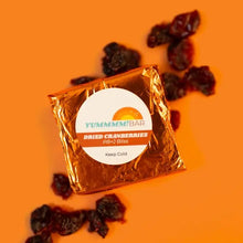 Load image into Gallery viewer, Yummmm!bar mini cranberry chip snack bar packaging with chocolate chips on an orange background